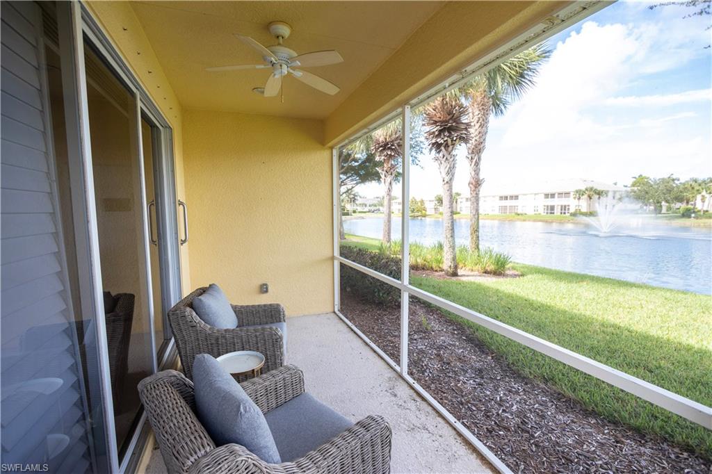 Screened patio with a ceiling fan, sliding glass door, and water feature backdrop