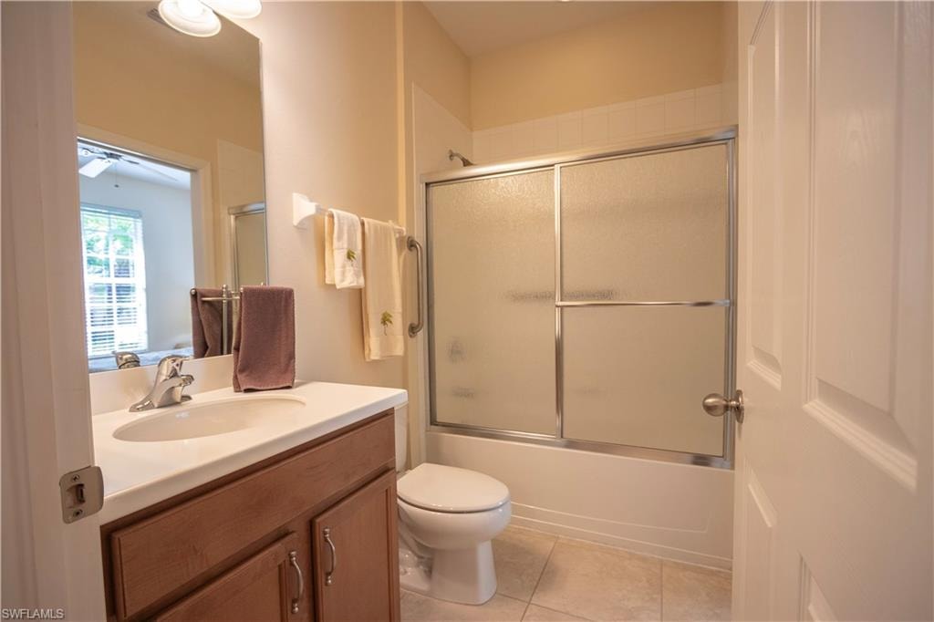 Bathroom featuring a wood-finish vanity with an integrated sink, satin nickel faucet, and overhead vanity lighting