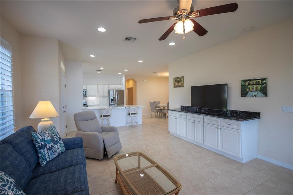 Recessed lighting, ceiling fan, plantation shutters, built-in cabinetry with dark countertop, and tiled flooring