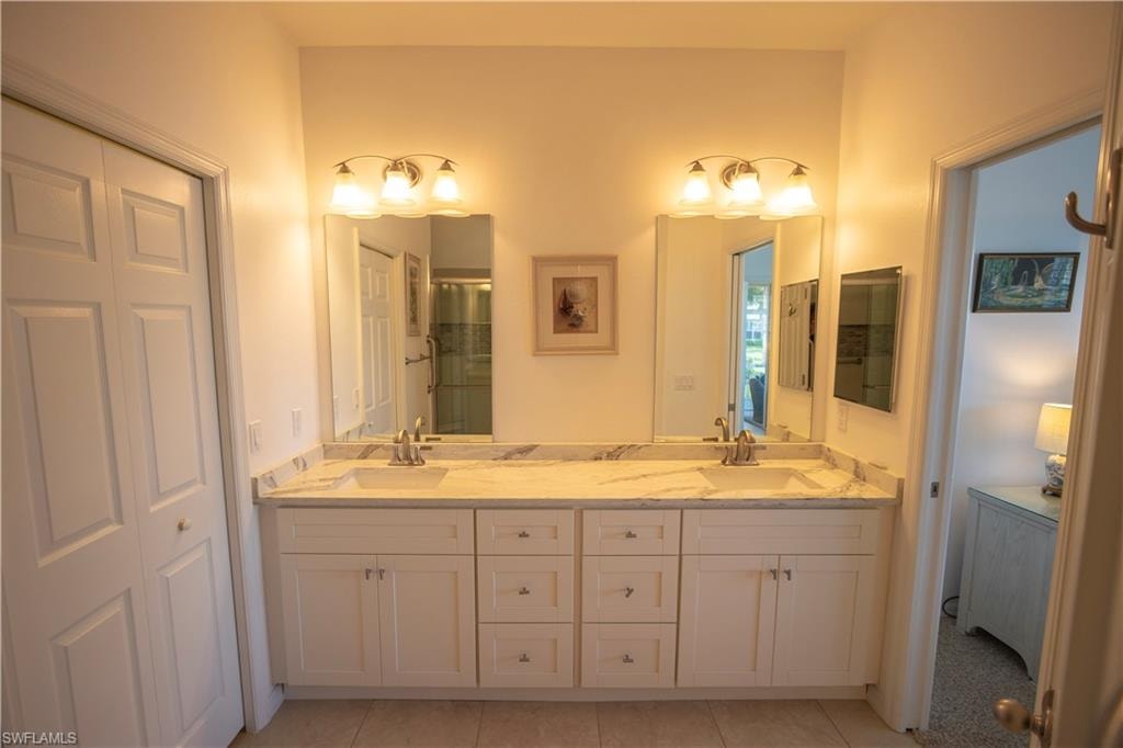 Dual vanity with undermount sinks, stone countertops, and individual mirrors
