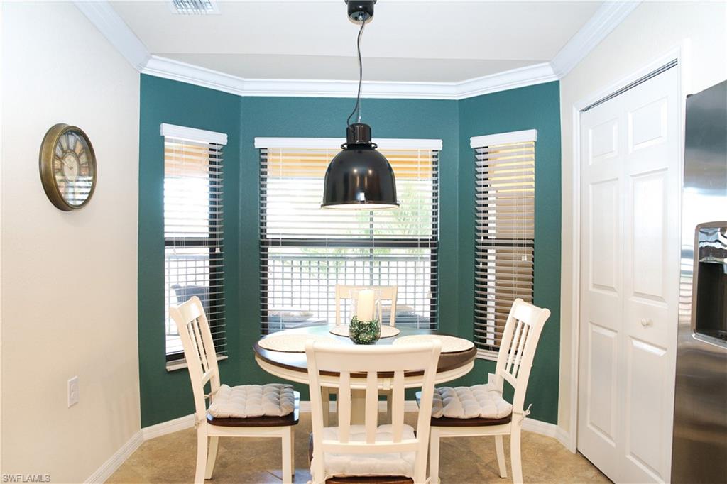 Bay window with blinds, bi-fold closet doors, and a suspended black pendant light fixture