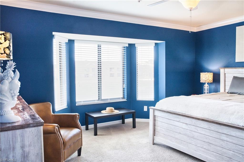 Bay window with white blinds, crown molding, and ceiling fan with integrated lighting