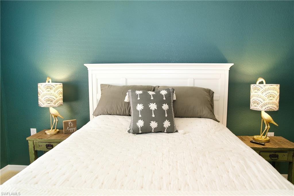 White paneled headboard against a teal accent wall
