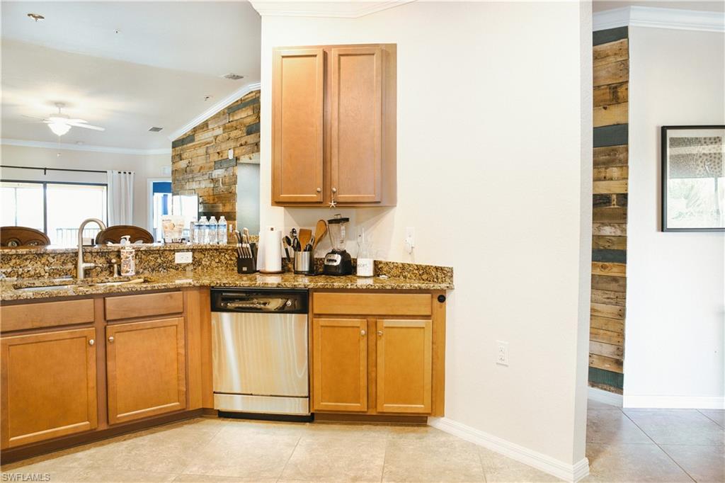 Kitchen featuring wood cabinetry, a stainless steel dishwasher, and a double basin sink
