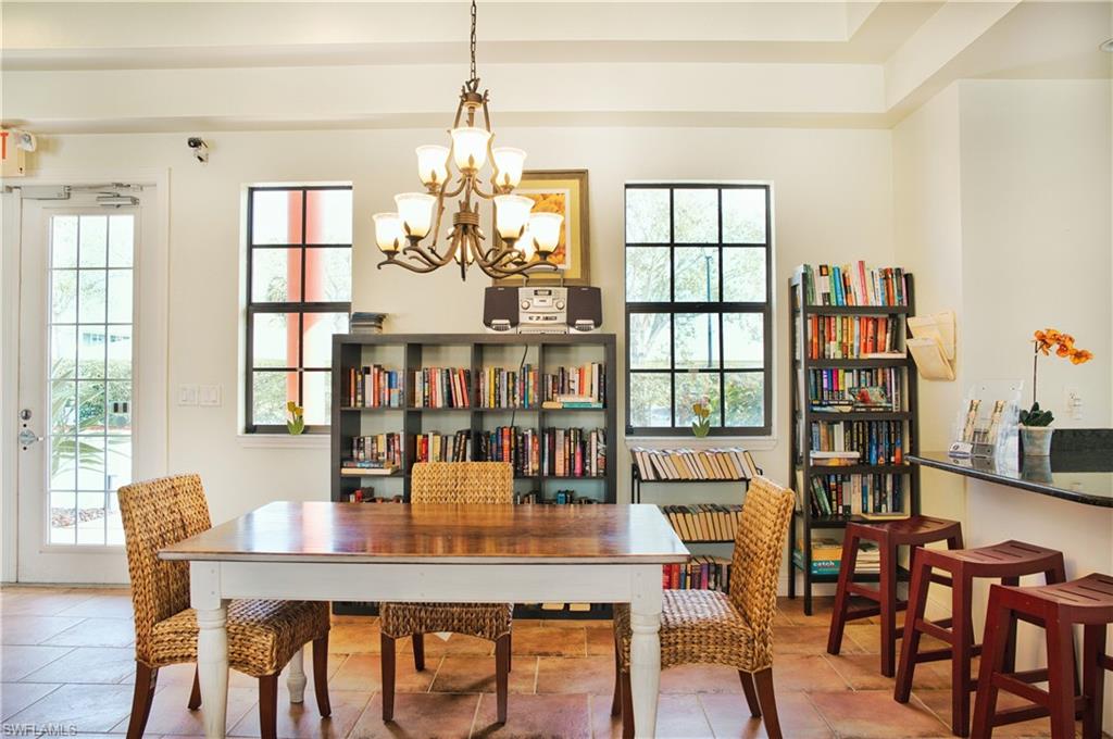 Recessed ceiling, transom window, tile flooring, built-in shelving, and a chandelier