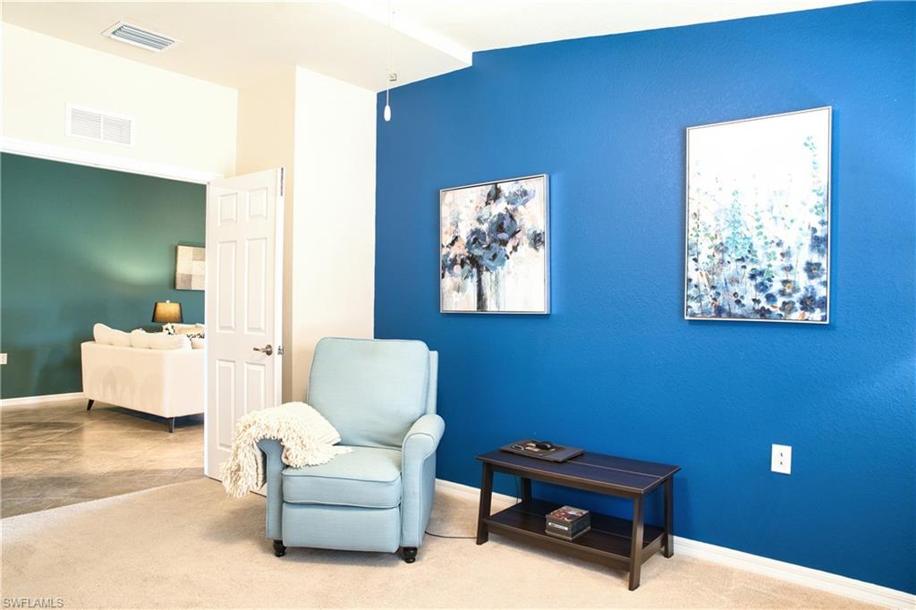 Carpeted flooring extending into a doorway with a paneled door, leading to a room with wood-finish flooring