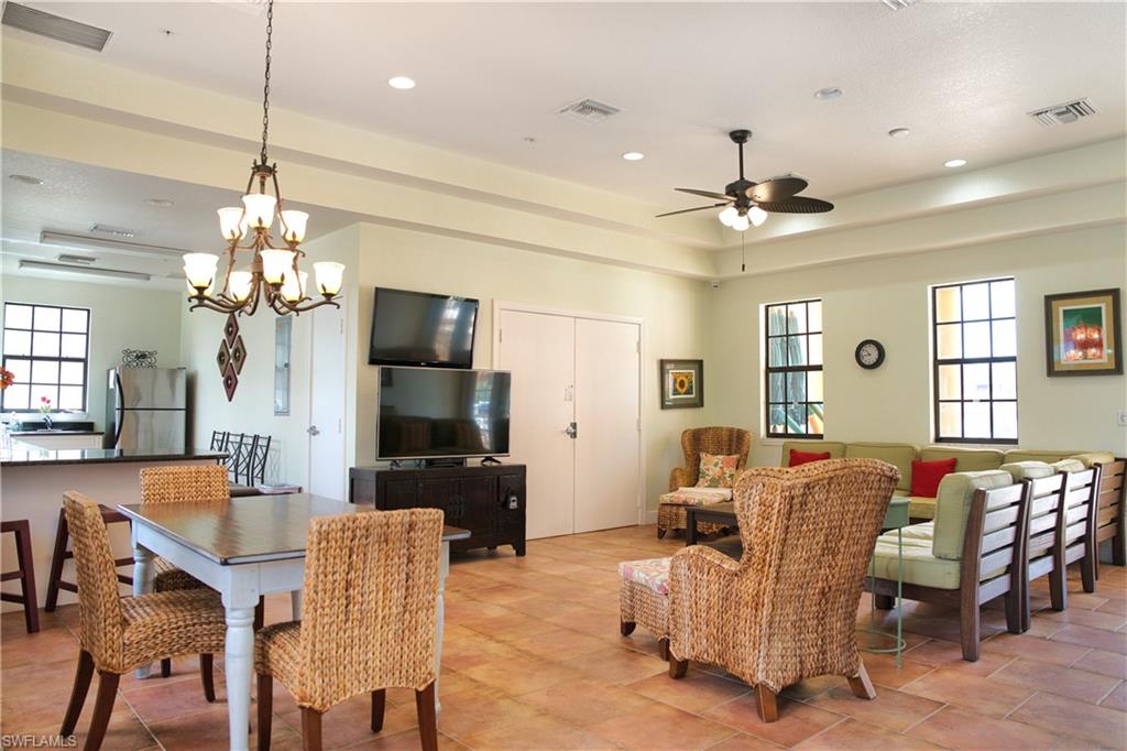 Open concept living area with tiled flooring, tray ceiling, recessed lighting, and ceiling fan