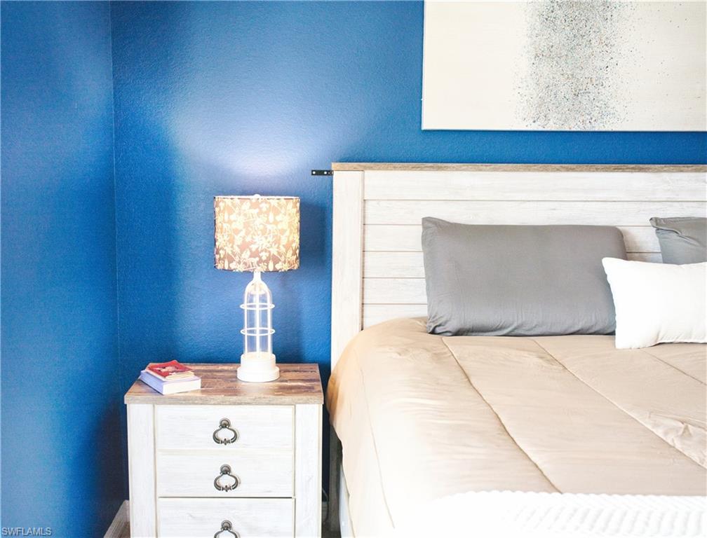 Reclaimed wood-finish headboard and nightstand with metal drawer pulls, featuring a textured wall finish