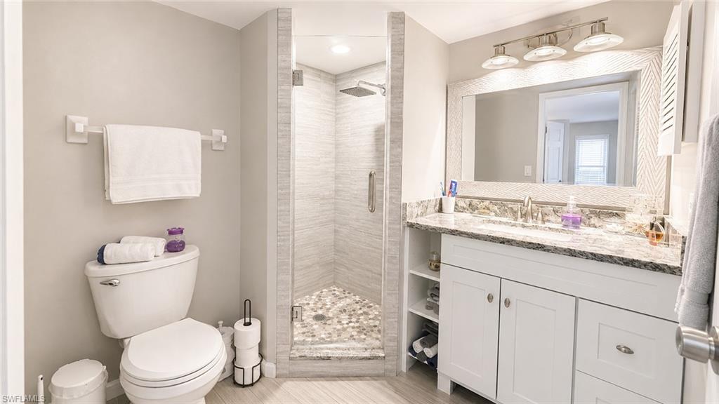 Glass-enclosed shower with a pebble floor and tiled walls