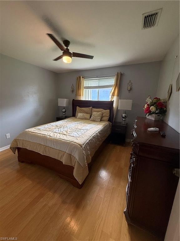 Wood-finish flooring with a ceiling fan and overhead lighting