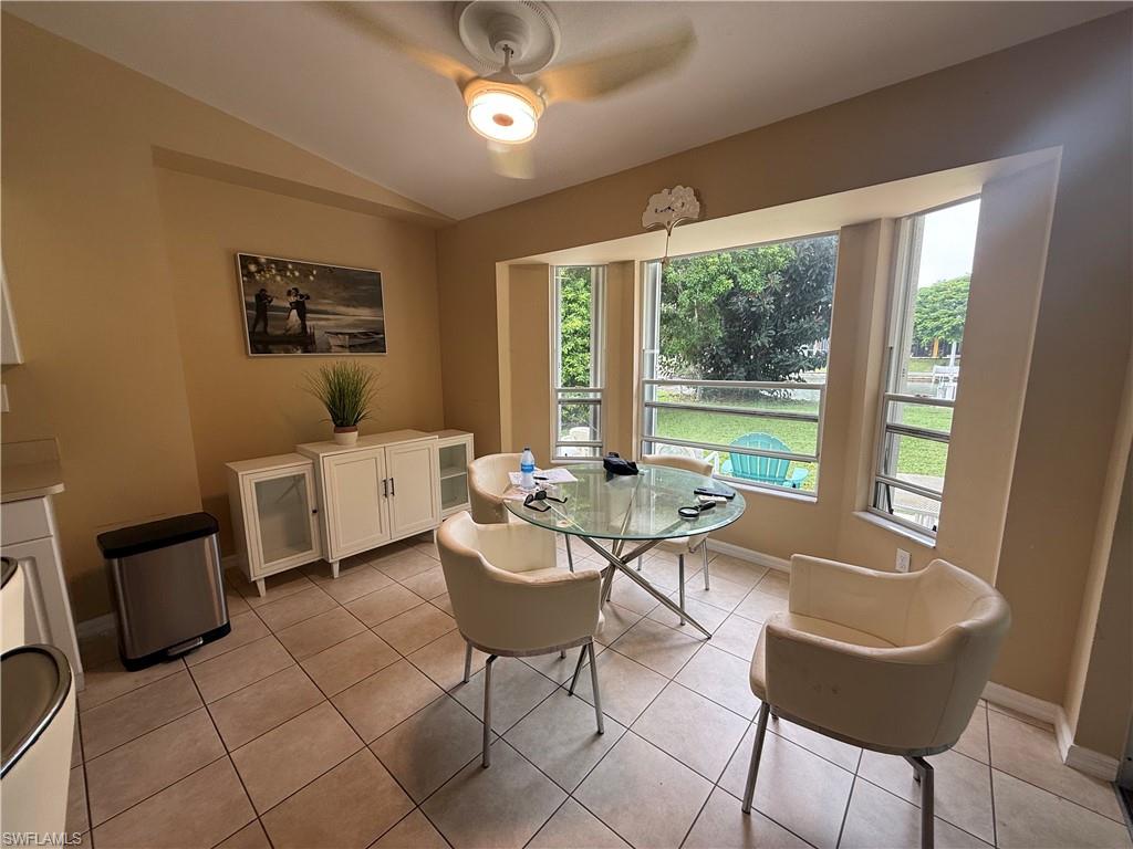 Recessed bay window, ceiling fan with integrated lighting, tile flooring, and a built-in buffet cabinet