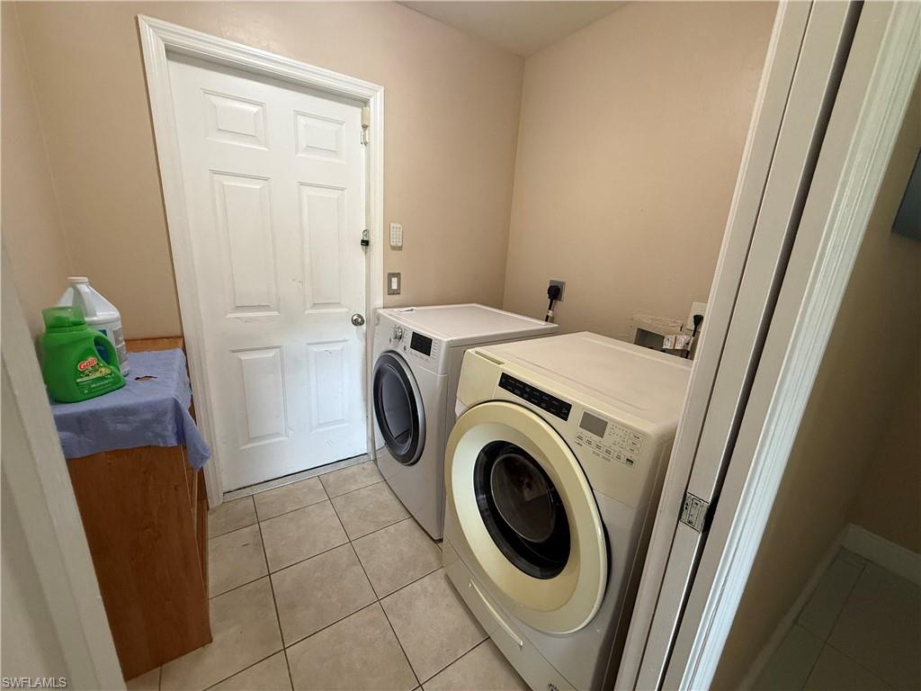 Laundry area featuring tile flooring, a white paneled door, and neutral wall paint