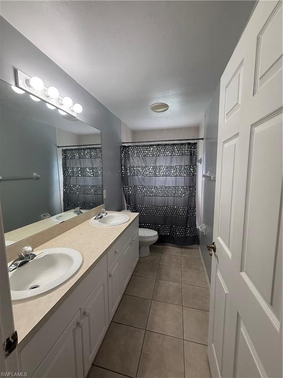 Dual vanity with undermount sinks, white cabinetry, and a large wall-mounted mirror