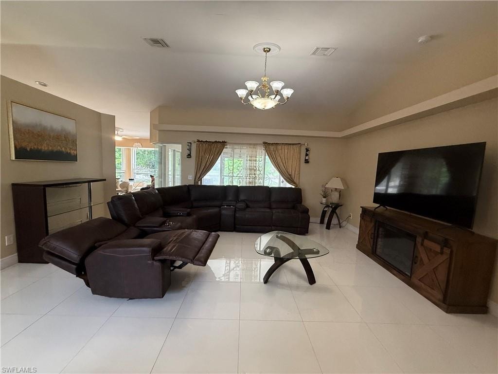 Vaulted ceiling with an elegant chandelier, recessed lighting, and tile flooring