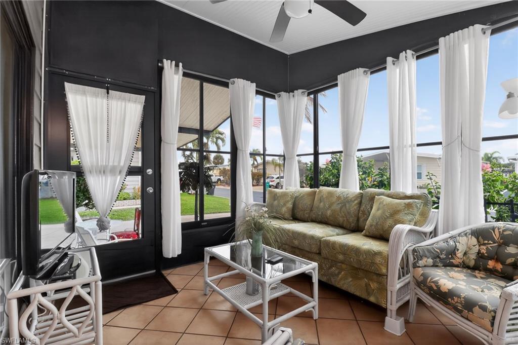 Enclosed sunroom featuring multiple large windows, a ceiling fan, and tiled flooring