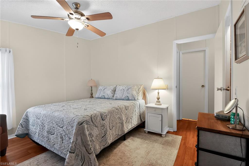 Bedroom featuring wood-finish flooring, neutral wall tones, and a ceiling fan with integrated lighting