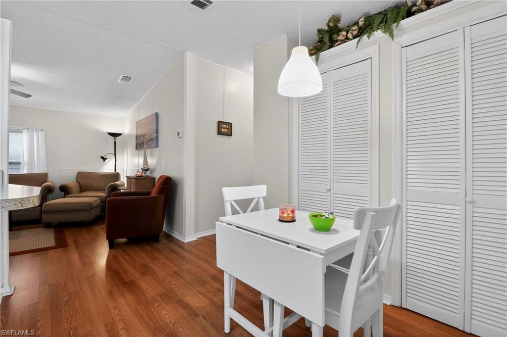 Dining area with wood-finish flooring and a contemporary pendant light fixture
