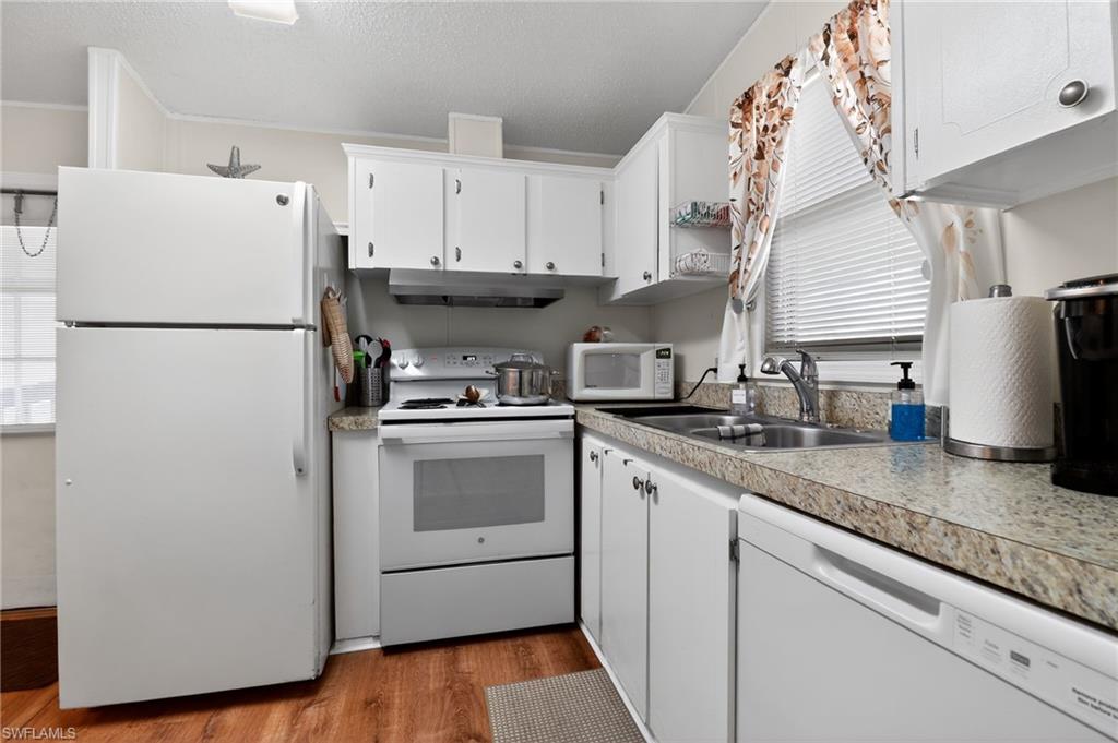 Kitchen featuring white cabinetry, wood-finish flooring, and speckled countertops