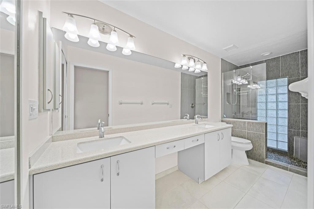 Dual vanity with light-colored countertops, undermount sinks, and white cabinetry