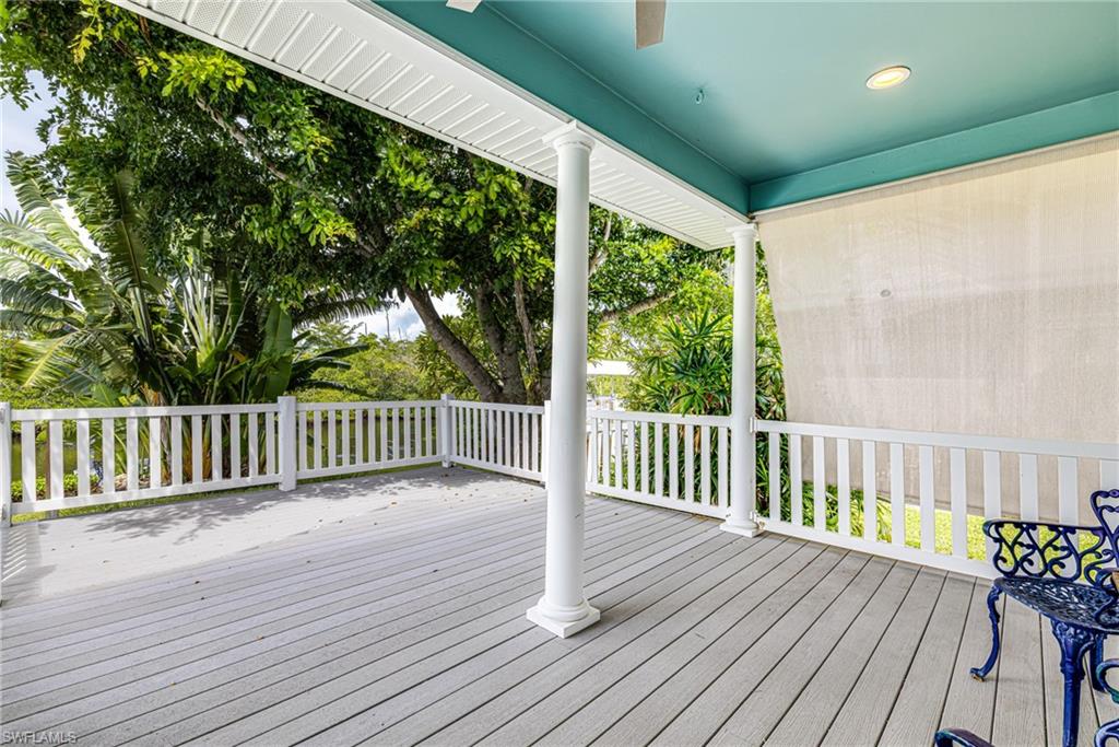 Covered outdoor patio with composite decking, white railing, recessed lighting, and ceiling fan