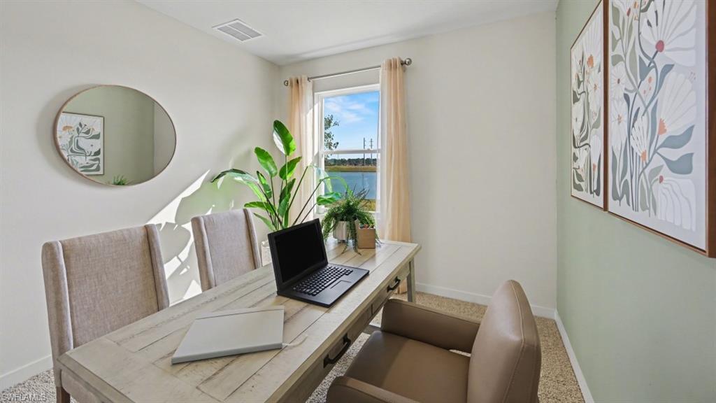 Dedicated room featuring a window with water scenery, light-toned walls, and carpeting
