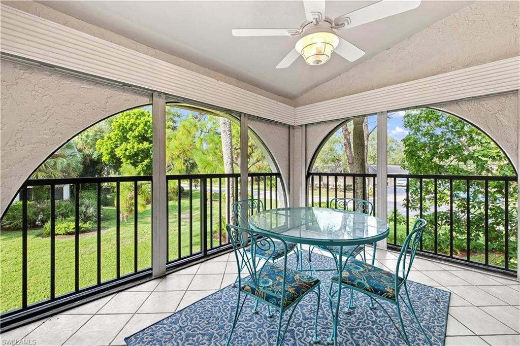 Screened patio with arched openings, textured ceiling, tiled flooring, and a ceiling fan