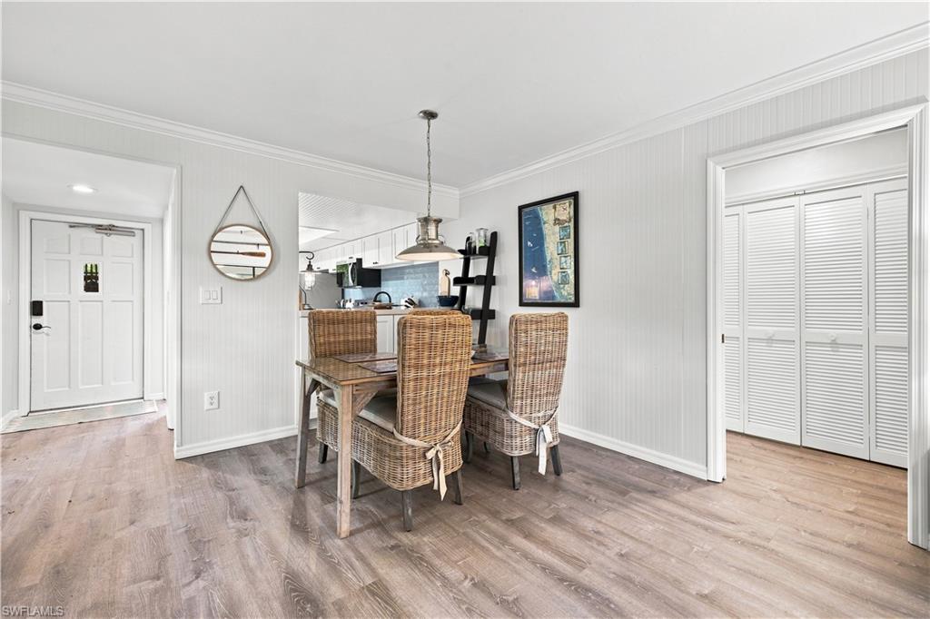 Wood-finish flooring throughout, beadboard wall paneling, and crown molding