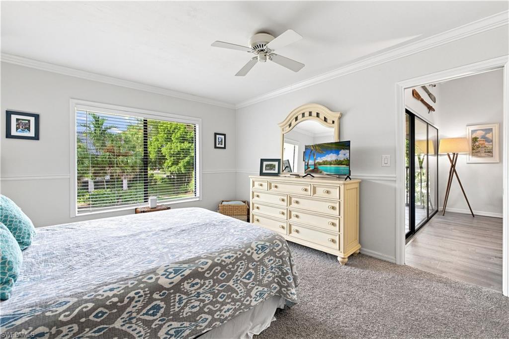 Spacious interior with carpet flooring, a large window with horizontal blinds, and a ceiling fan