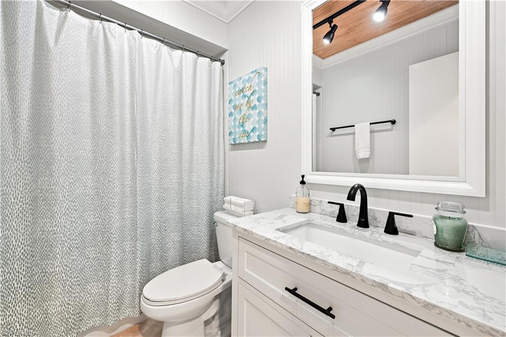 White vanity with a rectangular undermount sink, marble-finish countertop, and matte black faucet