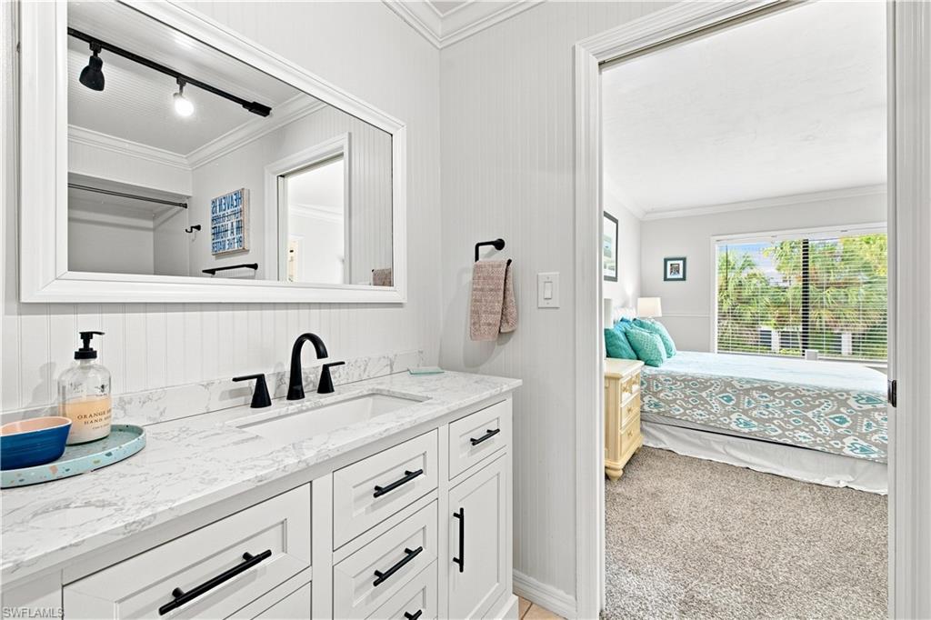 White vanity with black hardware, integrated sink, and a light-colored countertop