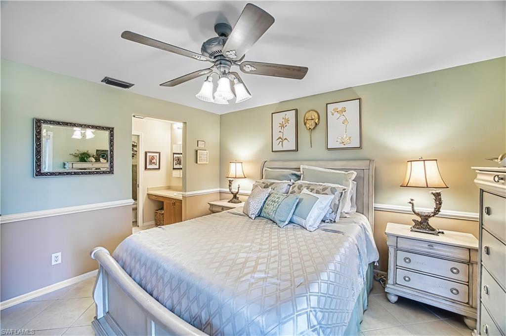 Ceiling fan with light fixture, tiled flooring, built-in desk, and chair rail molding