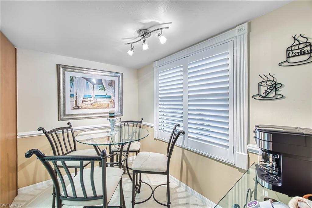 Recessed window featuring white louvered shutters and ornate trim