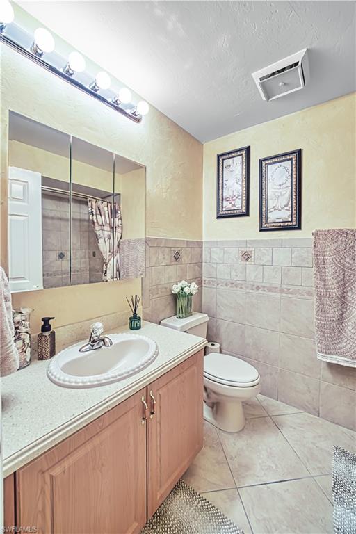 Vanity with a solid surface countertop, an oval inset sink, and a chrome faucet