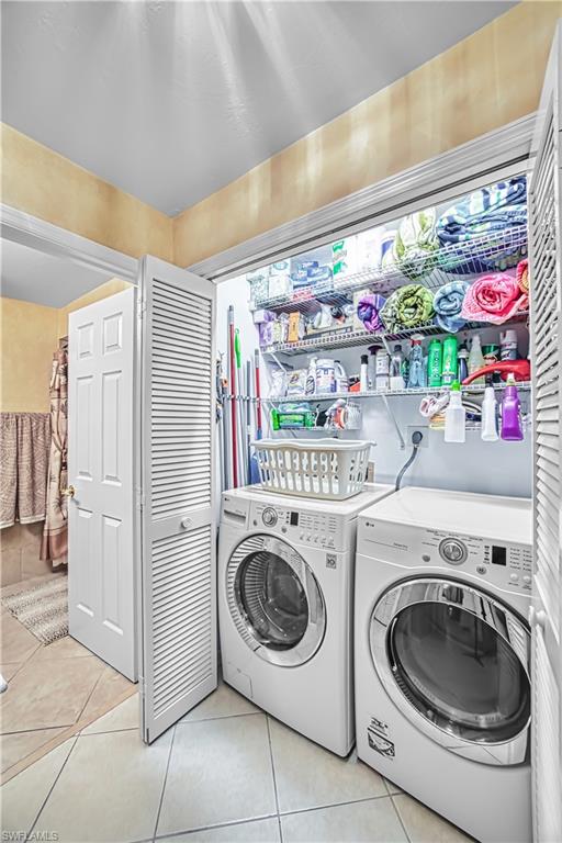 Laundry closet with louvered bi-fold doors, tile flooring, and integrated wire shelving