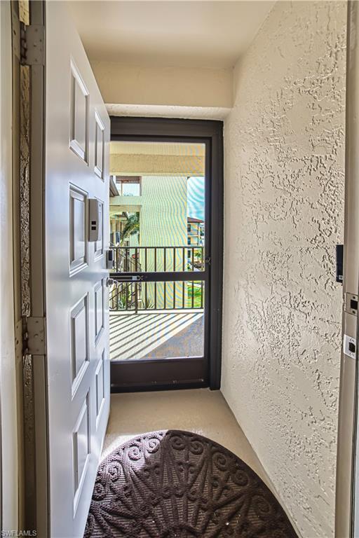 Entryway featuring a paneled door, textured wall finish, and a screened exterior door