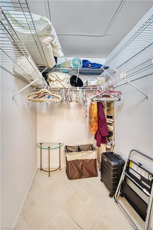 Wire shelving system with hanging rods, white walls, and tiled flooring