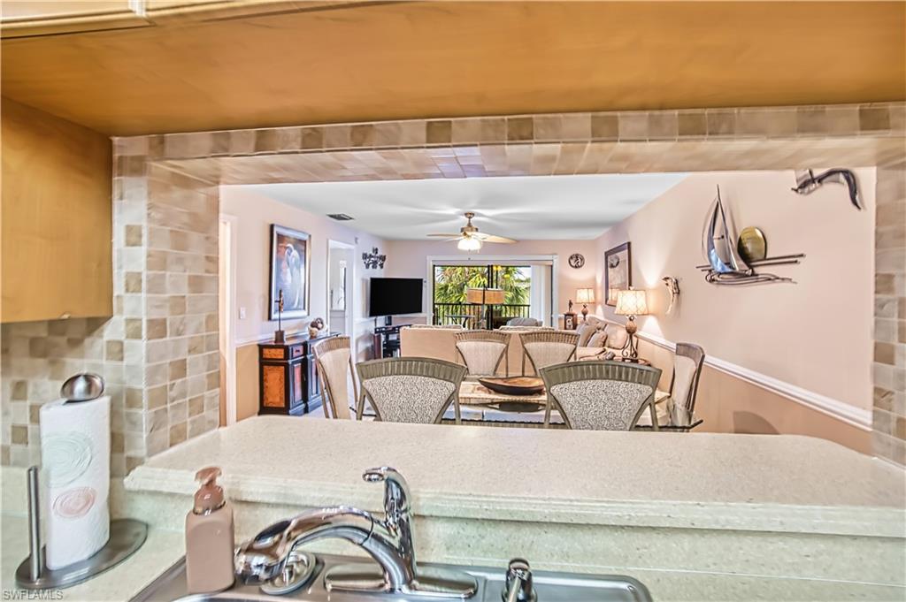 Kitchen pass-through with tile surround, stainless steel sink, and chrome faucet