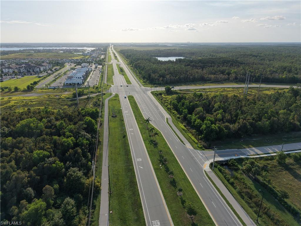Expansive land featuring a major thoroughfare and surrounding developed areas, including commercial buildings and residential structures