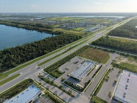 Expansive land parcel with direct road frontage, surrounded by established commercial properties and a substantial body of water