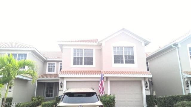 Stucco exterior with a tile roof, dual garage doors, and white-framed windows