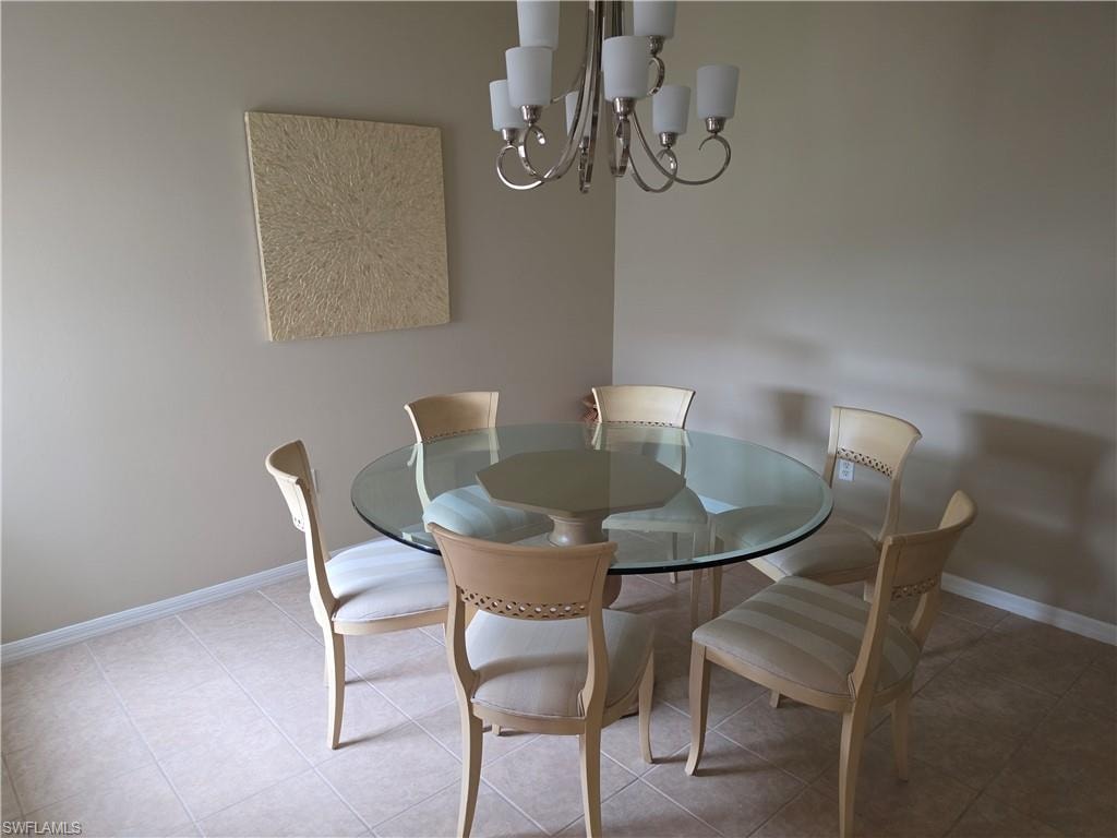 Neutral wall tones with a brushed nickel chandelier and ceramic tile flooring