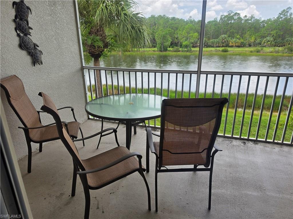 Screened patio featuring a solid concrete floor and a black metal railing