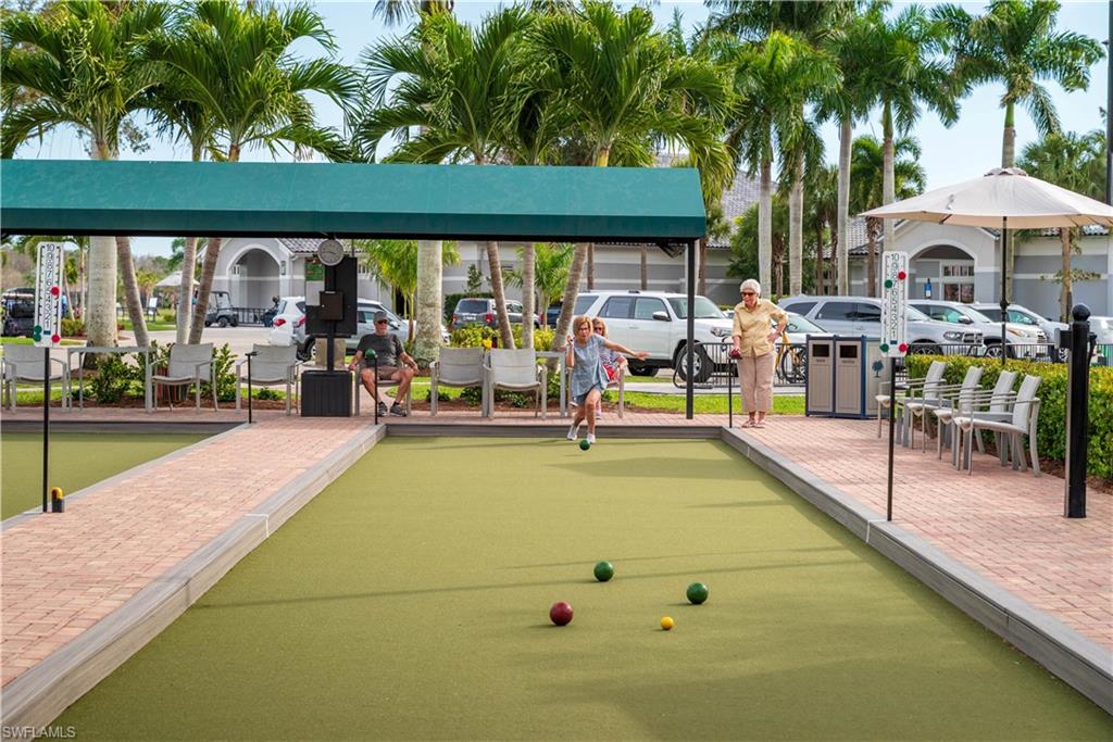 Bocce court featuring a synthetic turf playing surface, brick paver perimeter, and a shaded viewing area