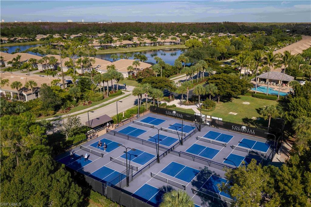 Multiple pickleball courts with black perimeter fencing and overhead lighting