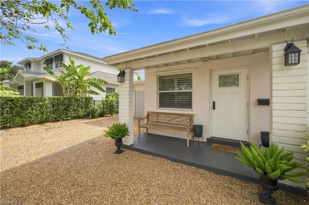Covered front porch with white door and transom window, flanked by two outdoor wall lanterns