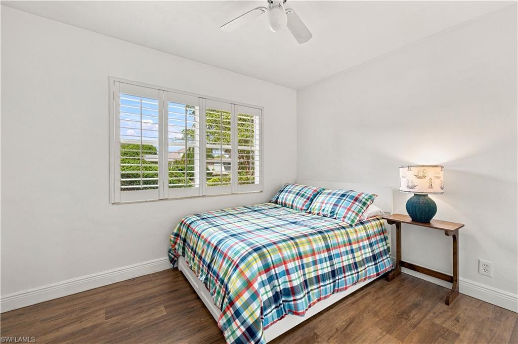White walls, wood-finish flooring, and a ceiling fan