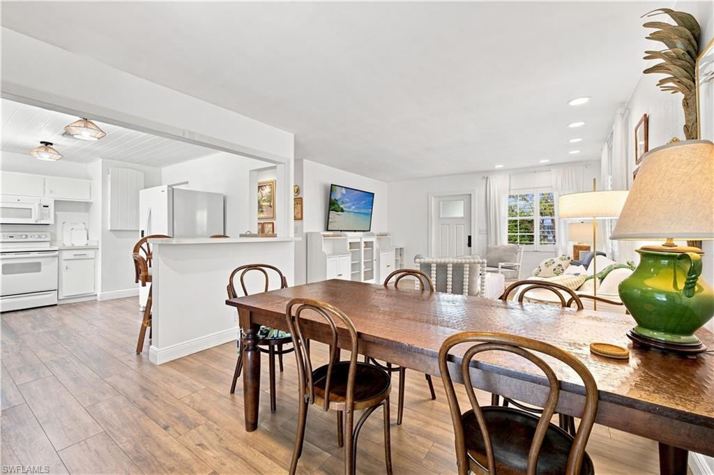 Open-concept living area with wood-finish flooring, recessed lighting, and white trim throughout