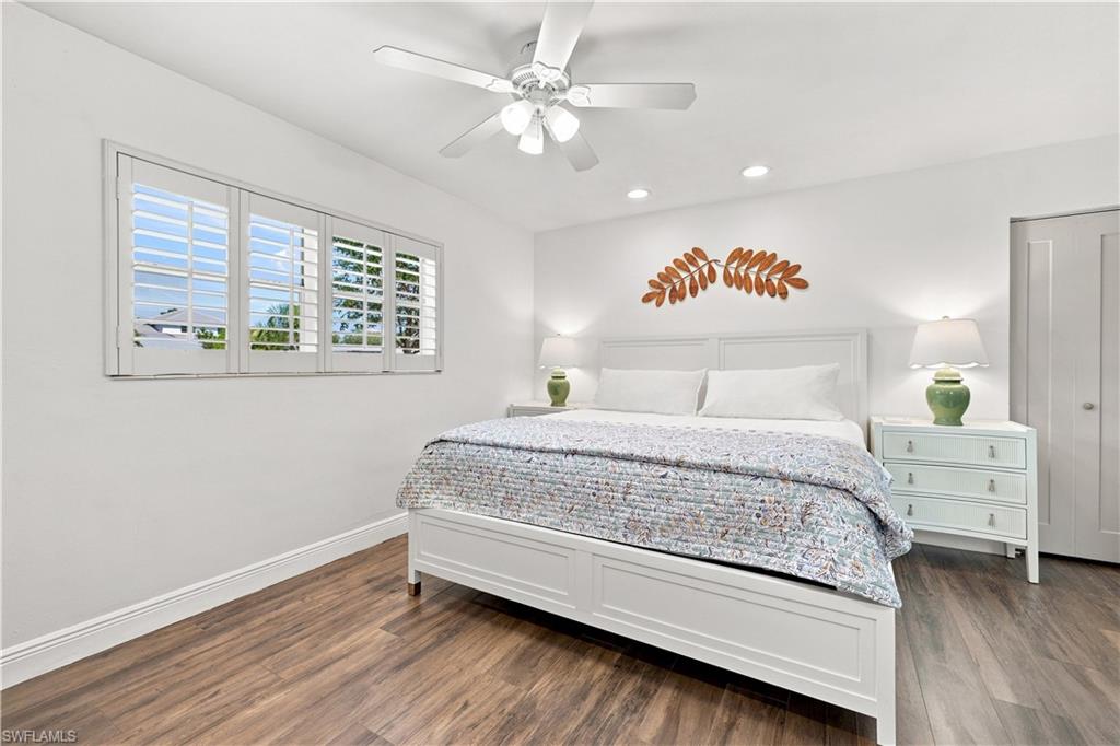 Wood-finish flooring, plantation shutters, recessed lighting, and a ceiling fan