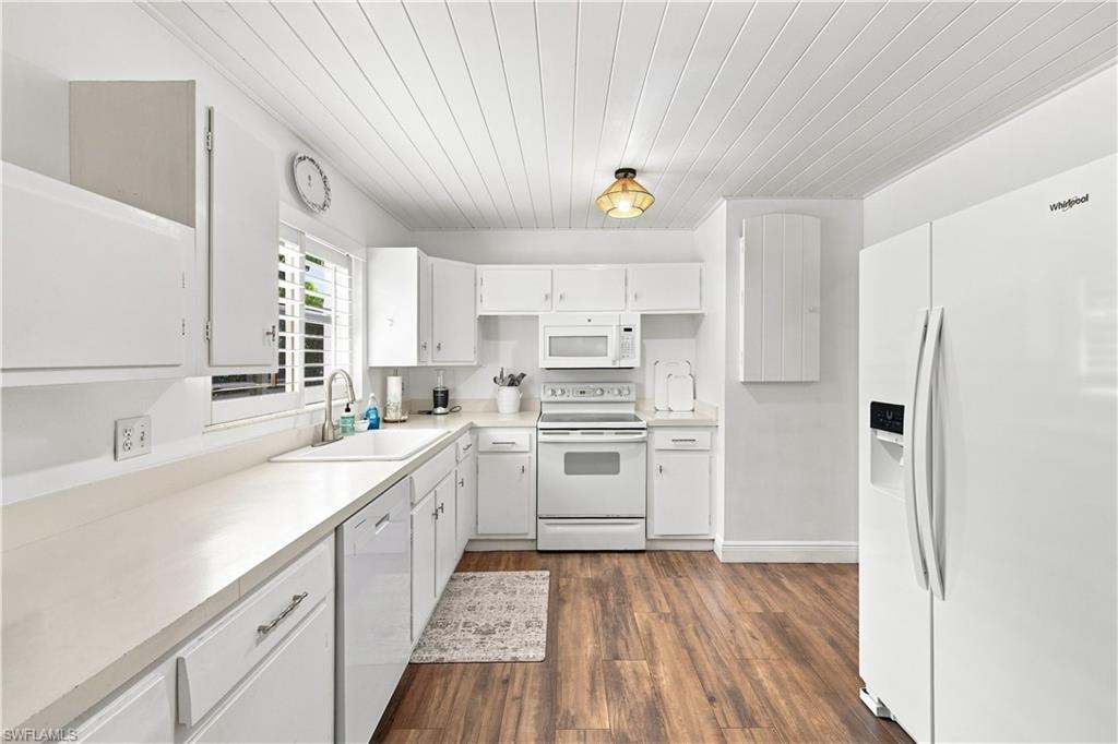Kitchen featuring wood-finish flooring, white cabinetry, integrated appliances, light-toned countertops, and a white beadboard ceiling