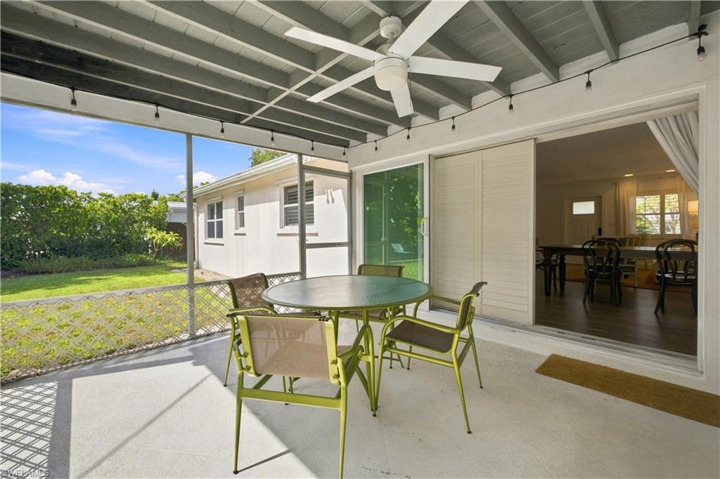 Screened patio with a ceiling fan, concrete flooring, and sliding glass doors